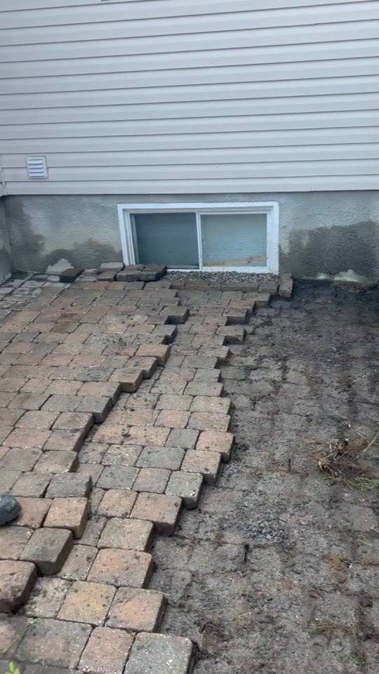 Interlock pavers lifted row by row on a weed-infested job in Gatineau