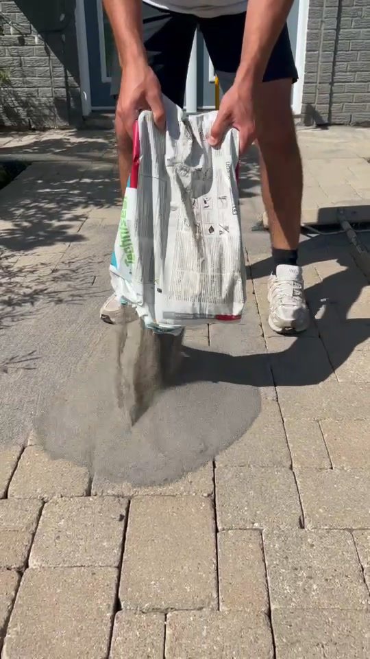 Polymeric sand poured onto interlock pavers during a Duo Vert restoration in Gatineau
